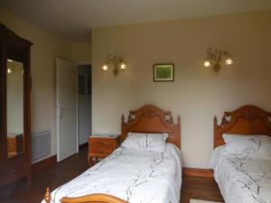a bedroom with two beds and a dresser and a mirror at La Madriguera Accommodation in Gardes-le-Pontaroux