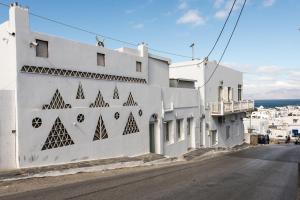 a white building with art on the side of it at Olympia in Mikonos