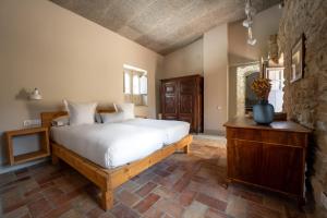 a bedroom with a large bed and a stone wall at Deco - Casa Castell de Peratallada in Peratallada