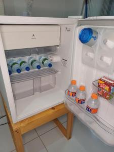 - un réfrigérateur ouvert avec des bouteilles d'eau et du lait dans l'établissement Hospede-se no IPSEP , em Recife , próximo ao Aeroporto Internacional dos Guararapes, à Récife