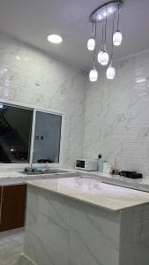 a kitchen with a white counter top with a microwave at Al Ashkhara Beach House in Al Ashkharah