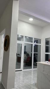 a living room with white walls and glass doors at Al Ashkhara Beach House in Al Sharqiyah