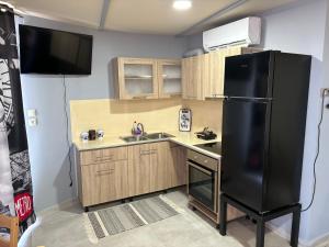 eine Küche mit einem schwarzen Kühlschrank und einer Spüle in der Unterkunft Silencio Villas in Lefkada Town