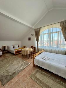 a hotel room with two beds and a table and chairs at PENSIUNEA ANA in Piatra Neamţ