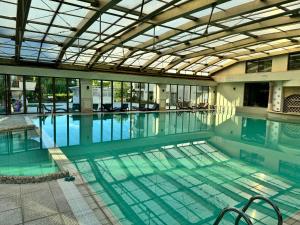 a large swimming pool with a glass ceiling at Sunshine apartment in Shkorpilovtsi