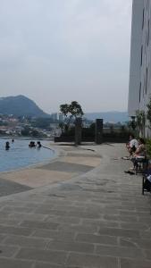 a group of people sitting on benches near a body of water at Apartment The Bay AisBeLL in Kuala