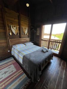 1 dormitorio con 1 cama en una habitación de madera en Cabana aconchegante Praia do Rosa Rosamarina, en Imbituba