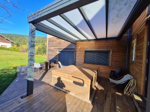 eine Terrasse mit einem Bett auf einem Haus in der Unterkunft Chalet La Dame du lac cocooning in Gérardmer