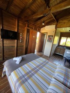 1 dormitorio con 1 cama y TV de pantalla plana en Cabana aconchegante Praia do Rosa Rosamarina, en Imbituba