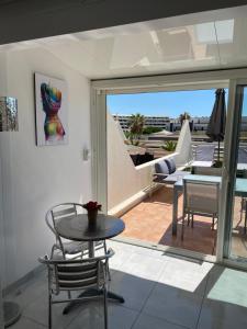 een kamer met een tafel en stoelen en een balkon bij The naturist glamour suite in Cap d'Agde
