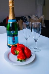 錫格蒂納的住宿－Lovely studio in the citycenter of Sigtuna，一瓶香槟和一些草莓放在桌子上