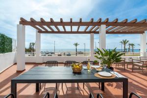 a patio with a table and chairs on a deck at AlmeriaSuite Mojacar Breeze Apartments in Mojácar