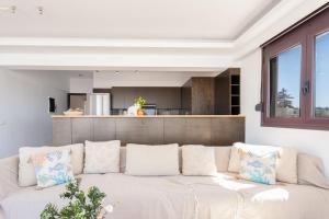 un divano bianco in un soggiorno con cucina di Cityscape Loft a Città di Rodi