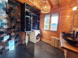 ein Badezimmer mit einem Waschbecken und einer Waschmaschine in der Unterkunft Chalet La Dame du lac cocooning in Gérardmer
