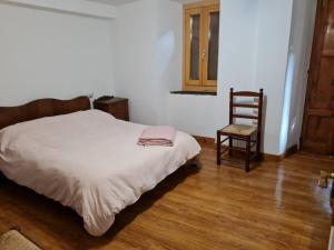 una camera da letto con un letto e una sedia di Casa cristina de les a Les