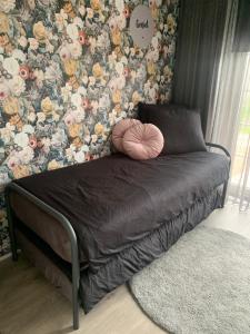 a bed in a bedroom with a flower wallpaper at B&B slapen in de veenhoop in De Veenhoop