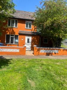 ein orangenes Haus mit einem Zaun davor in der Unterkunft Adorable 1-bedroom entire place with free parking in Cambridge