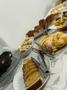 a table topped with different types of food on plates at Hotel CasaBlanca in Santana do Livramento +5 photos