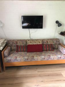 un sofá con almohadas y TV en la pared en Engbo, en Sindal
