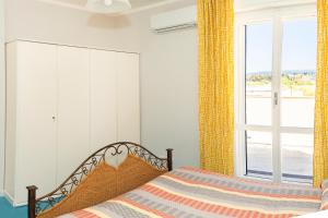 a bedroom with a bed and a large window at LoveAlghero stanze in attico vista mare in Alghero