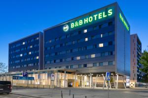 a large building with a sign for a hotel at B&B HOTEL Barcelona Viladecans in Viladecáns