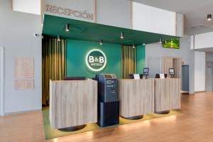 B&B HOTEL Barcelona Viladecans في فيلاكانس: مكتب bfg مع سجل نقدي في مبنى