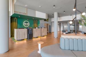 a lobby with a waiting area in a building at B&B HOTEL Barcelona Viladecans in Viladecáns