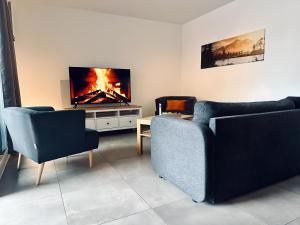 a living room with two couches and a flat screen tv at FeWo Am Citybogen - mit Aufzug und Loggia in Nordhorn