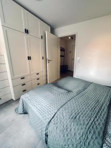 諾德霍恩的住宿－FeWo Am Citybogen - mit Aufzug und Loggia，一间卧室配有一张床和白色橱柜