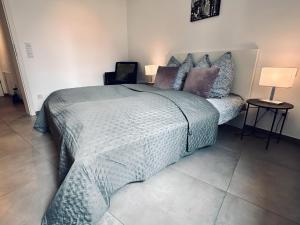 a bedroom with a large bed and two lamps at FeWo Am Citybogen Aufzug & Loggia in Nordhorn