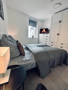 諾德霍恩的住宿－FeWo Am Citybogen - mit Aufzug und Loggia，一间卧室配有一张床、白色橱柜和一台电视机