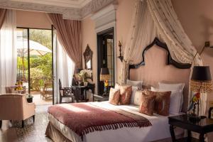 a bedroom with a large bed with a canopy at Palais Ronsard Relais & Chateaux in Marrakesh +63 photos