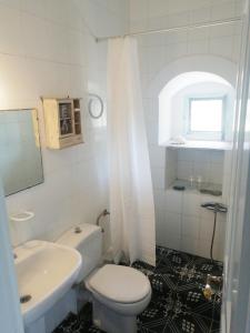 een witte badkamer met een toilet en een wastafel bij Evgenia's Traditional House in Logothetiánika