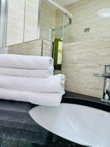 a bathroom with a sink and towels on a counter at Pensjonat Kotwica in Międzywodzie