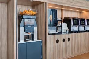 a coffee shop with a counter with a basket of oranges at B&B HOTEL Barcelona Viladecans in Viladecáns