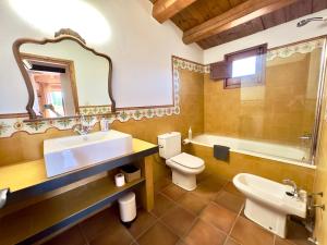 uma casa de banho com um lavatório, um WC e uma banheira em Mas Camins em Avinyonet de Puigventós