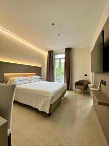 ポルト・サント・ステーファノにあるホテル ヴィラ ドミジアのベッドルーム(大型ベッド1台、窓付)