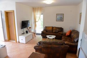 sala de estar con sofá de cuero y TV en Holiday Home Vemini en Mostar