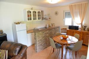 a kitchen with a table and a kitchen with a refrigerator at Holiday Home Vemini in Mostar