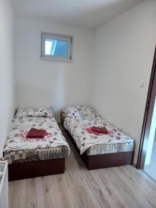 2 Betten in einem kleinen Zimmer mit Fenster in der Unterkunft Flower Bike in Štúrovo