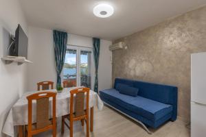 a living room with a blue couch and a table at Family Resort Santa Maria in Stara Novalja