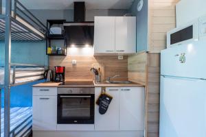 una piccola cucina con armadietti bianchi e frigorifero di Le Cosmos Villarembert - Studio 5p vue montagne a Villarembert