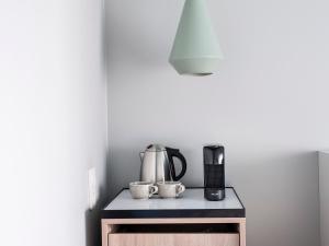 a counter with a coffee maker and two cups on it at Numa Berlin Kudamm in Berlin