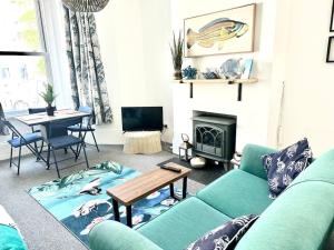 a living room with a green couch and a table at Love St Leonards Flat in St. Leonards
