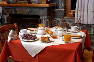 a table with a breakfast of fruit and biscuits and orange juice at Hotel Semeli in Goura