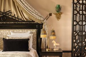 een slaapkamer met een zwart-wit bed en een lamp bij Palais Ronsard Relais & Chateaux in Marrakesh