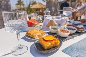 ステリダにあるNaxos Cave Suitesの食器一皿と水一杯のテーブル