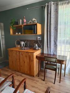 eine Küche mit einem Holztisch und einem Holzschrank in der Unterkunft Bird Song in Roodepoort