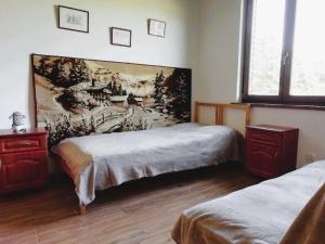 sypialnia z 2 łóżkami i obrazem na ścianie w obiekcie Chata gościom rada w mieście Ustrzyki Dolne