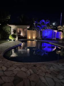 ein Pool in der Nacht mit blauen Lichtern in der Unterkunft Pousada Blanca Inn in Búzios